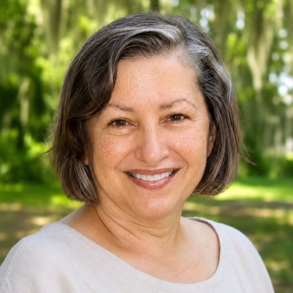 Woman with cropped hair smiles in a park