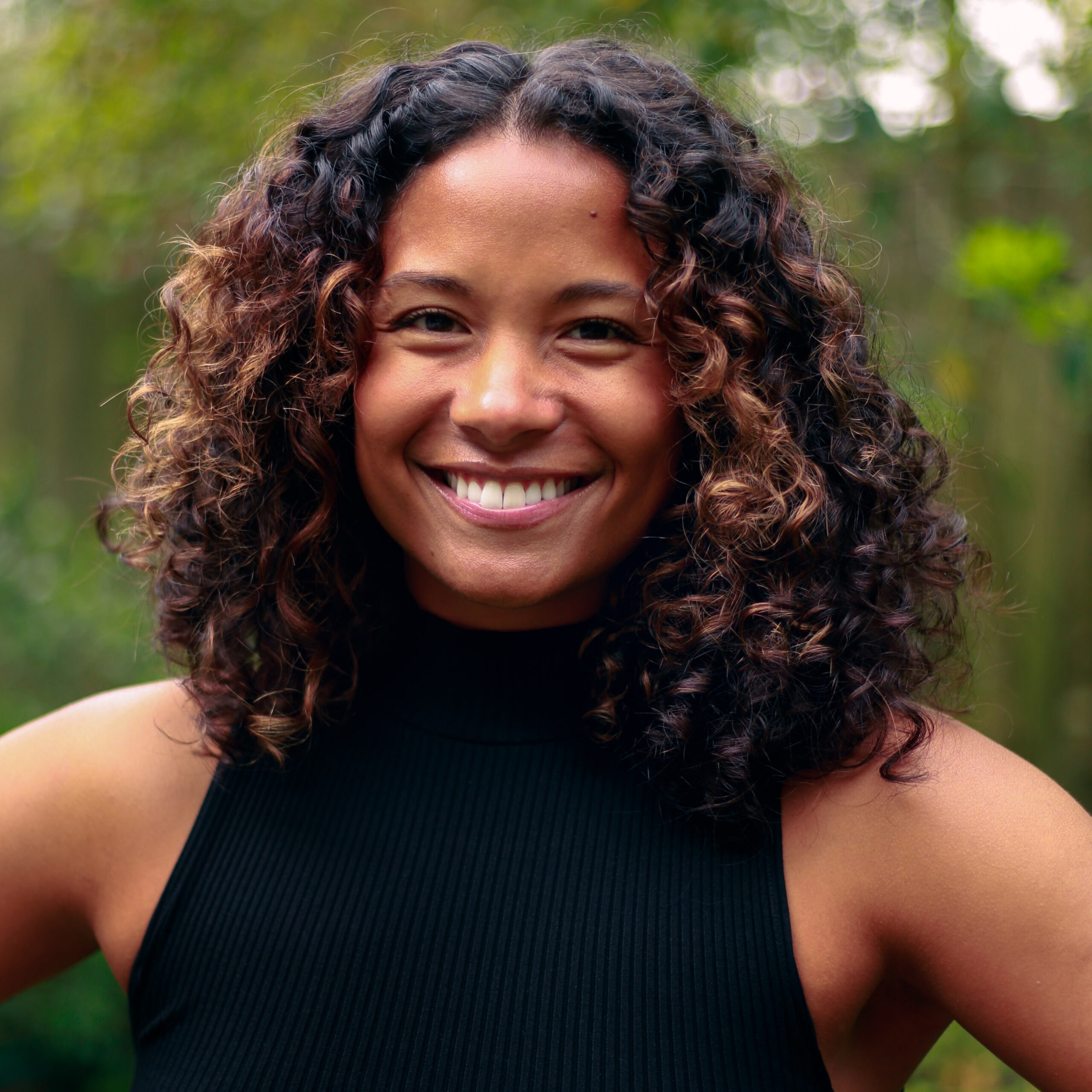 Woman with curly hair wears a black top